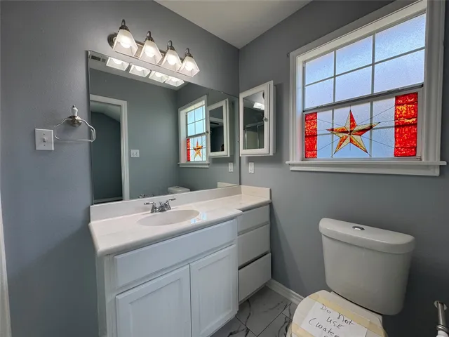 a bathroom with a sink a toilet and a mirror