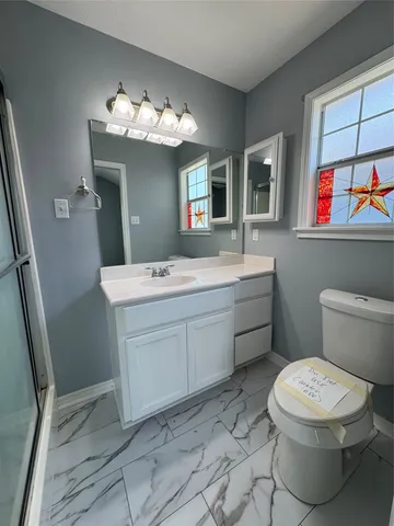 a bathroom with a toilet sink and mirror