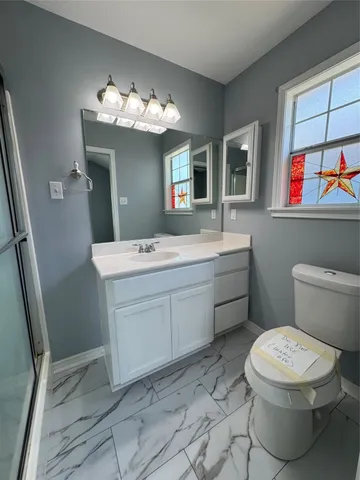 a bathroom with a toilet sink and mirror