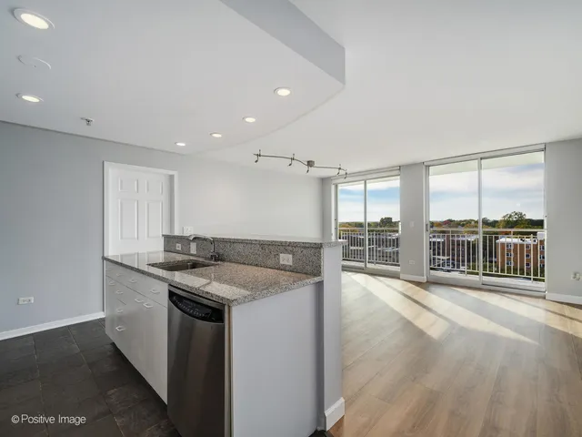 a kitchen with granite countertop a sink and a refrigerator
