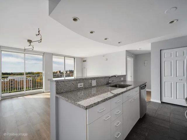 a kitchen with granite countertop a sink and a refrigerator