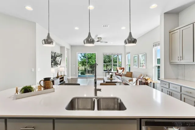 a kitchen with a sink a counter space a large window and stainless steel appliances