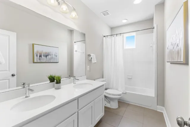 a bathroom with a granite countertop sink a toilet a large mirror and shower