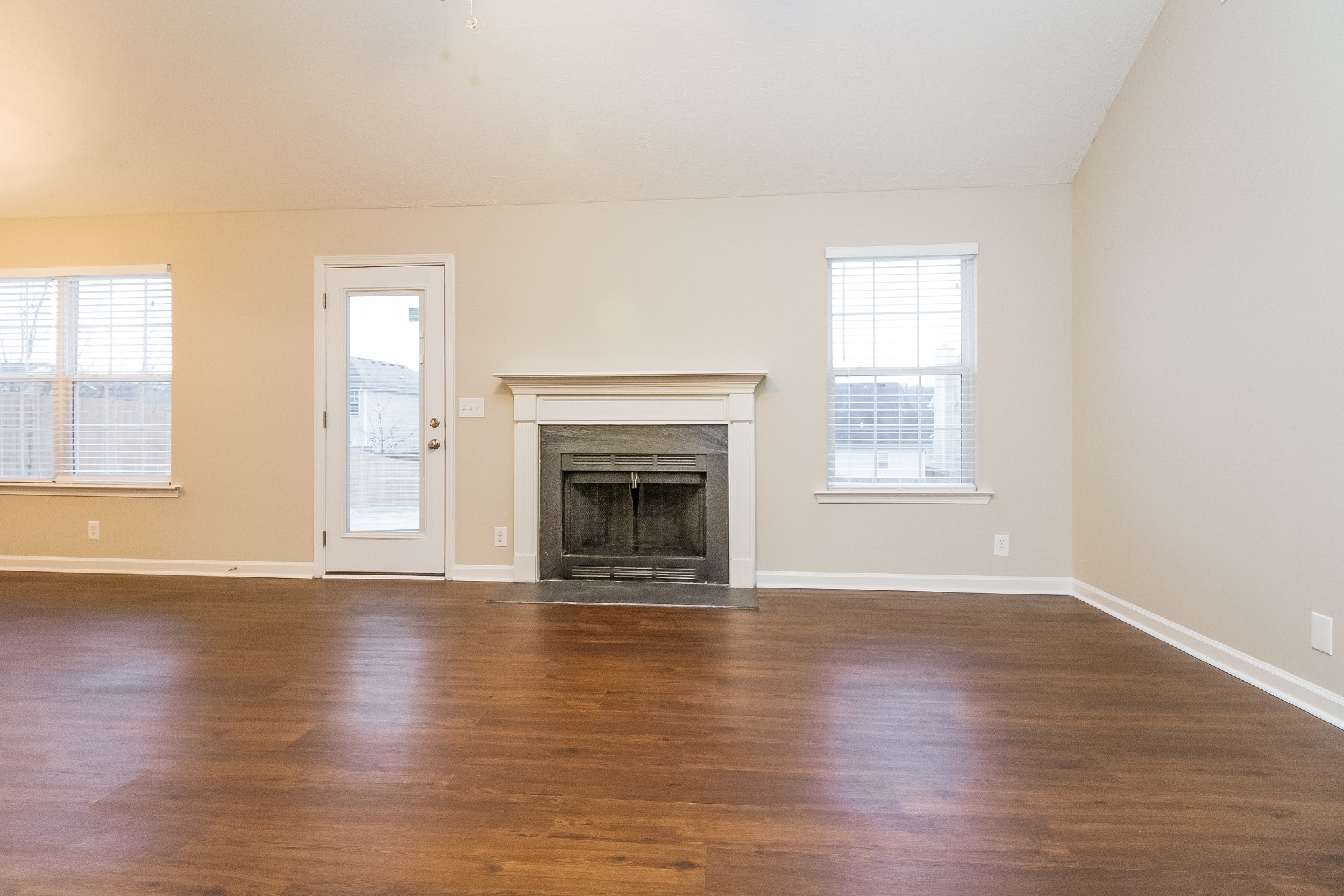 Undisclosed Address Antioch, TN 37013 - Photo 3 of 17 an empty room with wooden floor fireplace and windows