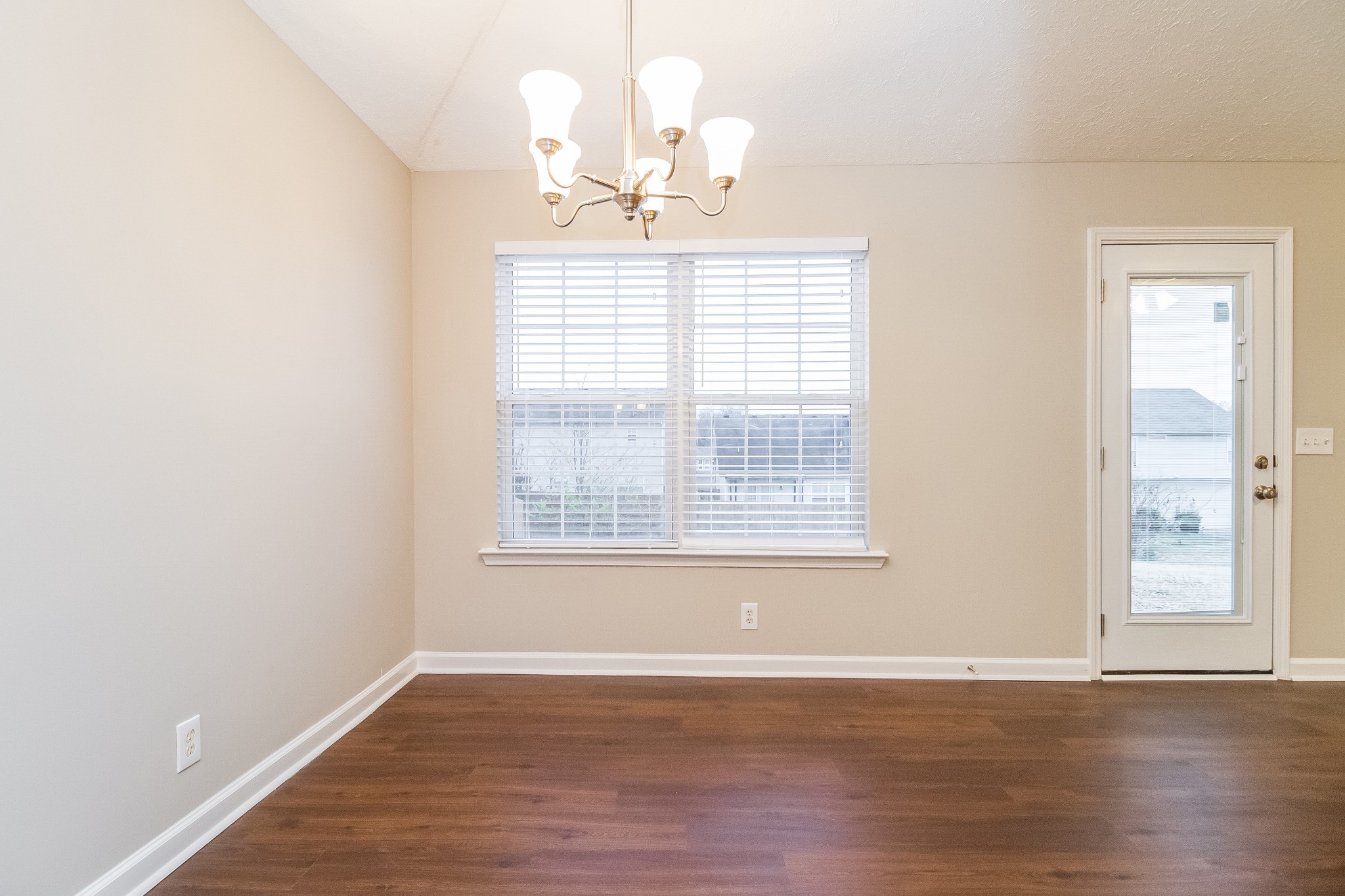 Undisclosed Address Antioch, TN 37013 - Photo 5 of 17 an empty room with wooden floor chandelier and window