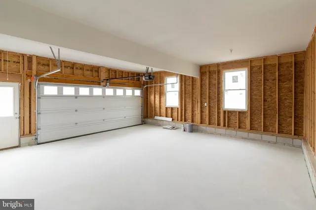 an empty room with wooden floor fireplace and windows