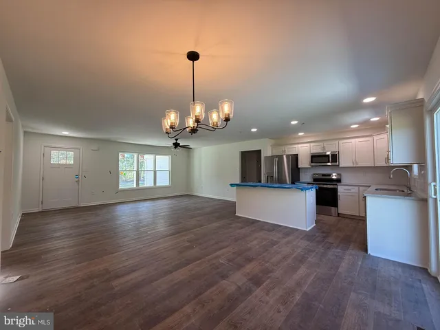 a kitchen with stainless steel appliances granite countertop a stove a sink dishwasher a refrigerator and a microwave