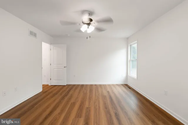 wooden floor in an empty room with a window
