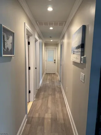 a view of a hallway with wooden floor