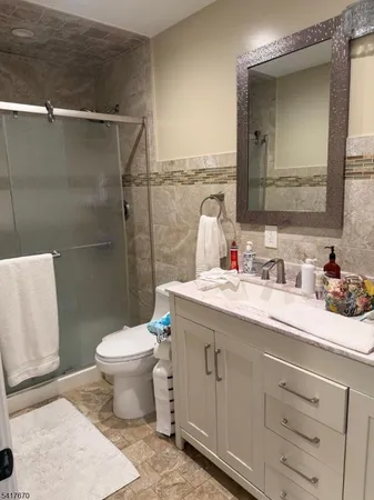 a bathroom with a granite countertop sink toilet and shower