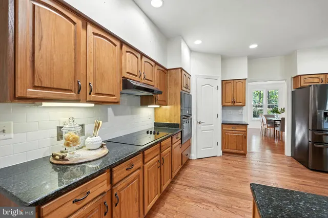 a view of an empty room with wooden floor fireplace and a window