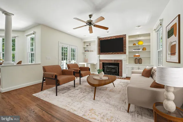 a view of a living room kitchen with a wooden floor and windows