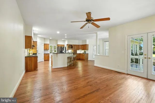 a kitchen with stainless steel appliances a dining table chairs refrigerator and sink