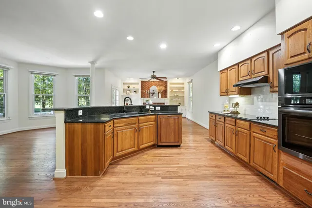 a kitchen with stainless steel appliances kitchen island granite countertop a refrigerator and a stove top oven