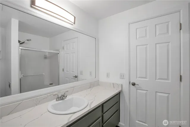 a bathroom with a sink toilet vanity and shower