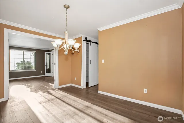 an empty room with windows fireplace and wooden floor