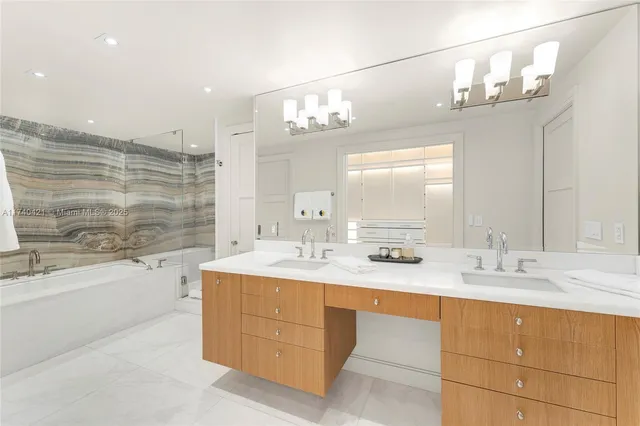 a bathroom with a sink double vanity granite tub shower and a mirror