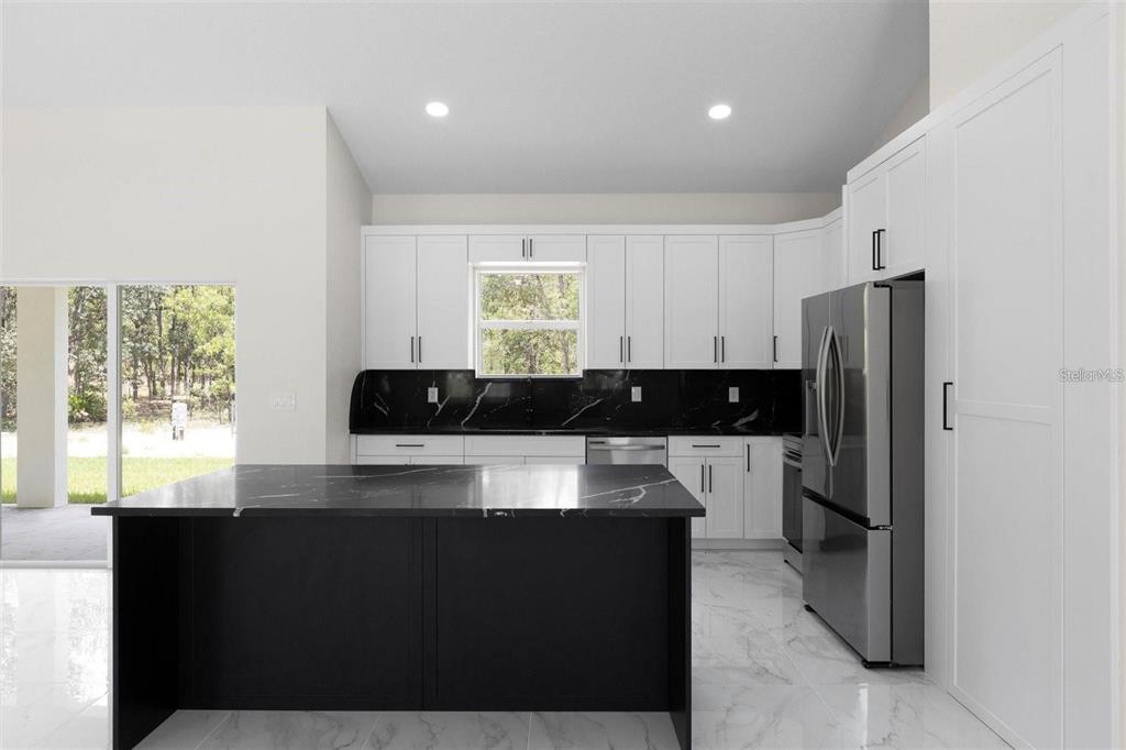 13619 Southwest 78th Place Dunnellon, FL 34432 - Photo 8 of 31 a kitchen with a refrigerator and a stove top oven