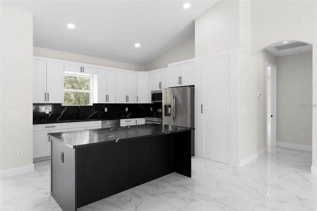 13619 Southwest 78th Place Dunnellon, FL 34432 - Photo 9 of 31 a kitchen with a refrigerator and a stove top oven