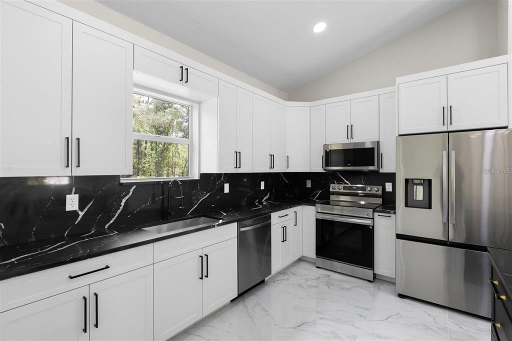 13619 Southwest 78th Place Dunnellon, FL 34432 - Photo 10 of 31 a kitchen with a sink and stainless steel appliances