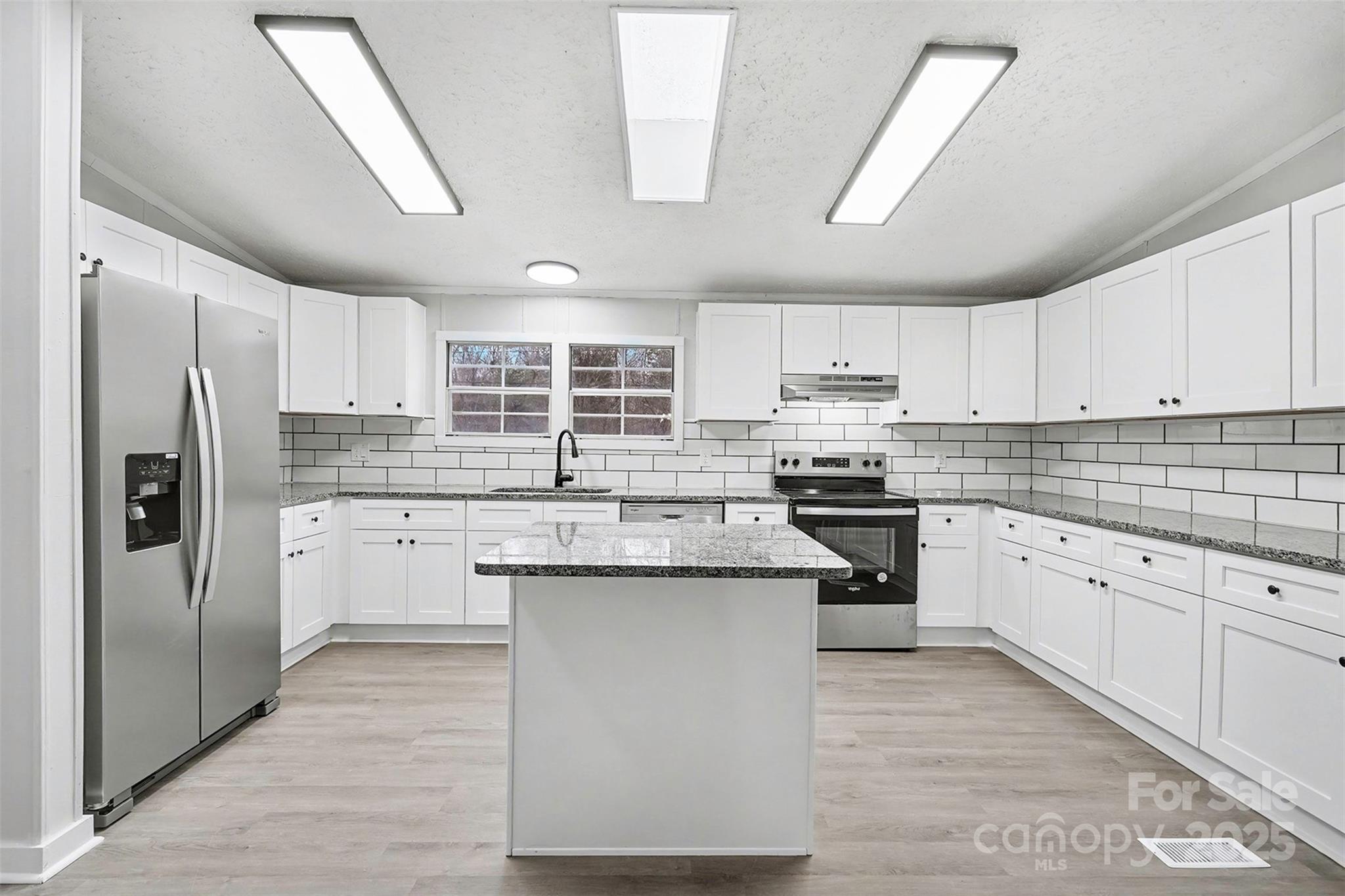 115 Lakeview Lane China Grove, NC 28023 - Photo 11 of 32 a kitchen with stainless steel appliances granite countertop a stove top oven a refrigerator a sink and dishwasher with wooden floor