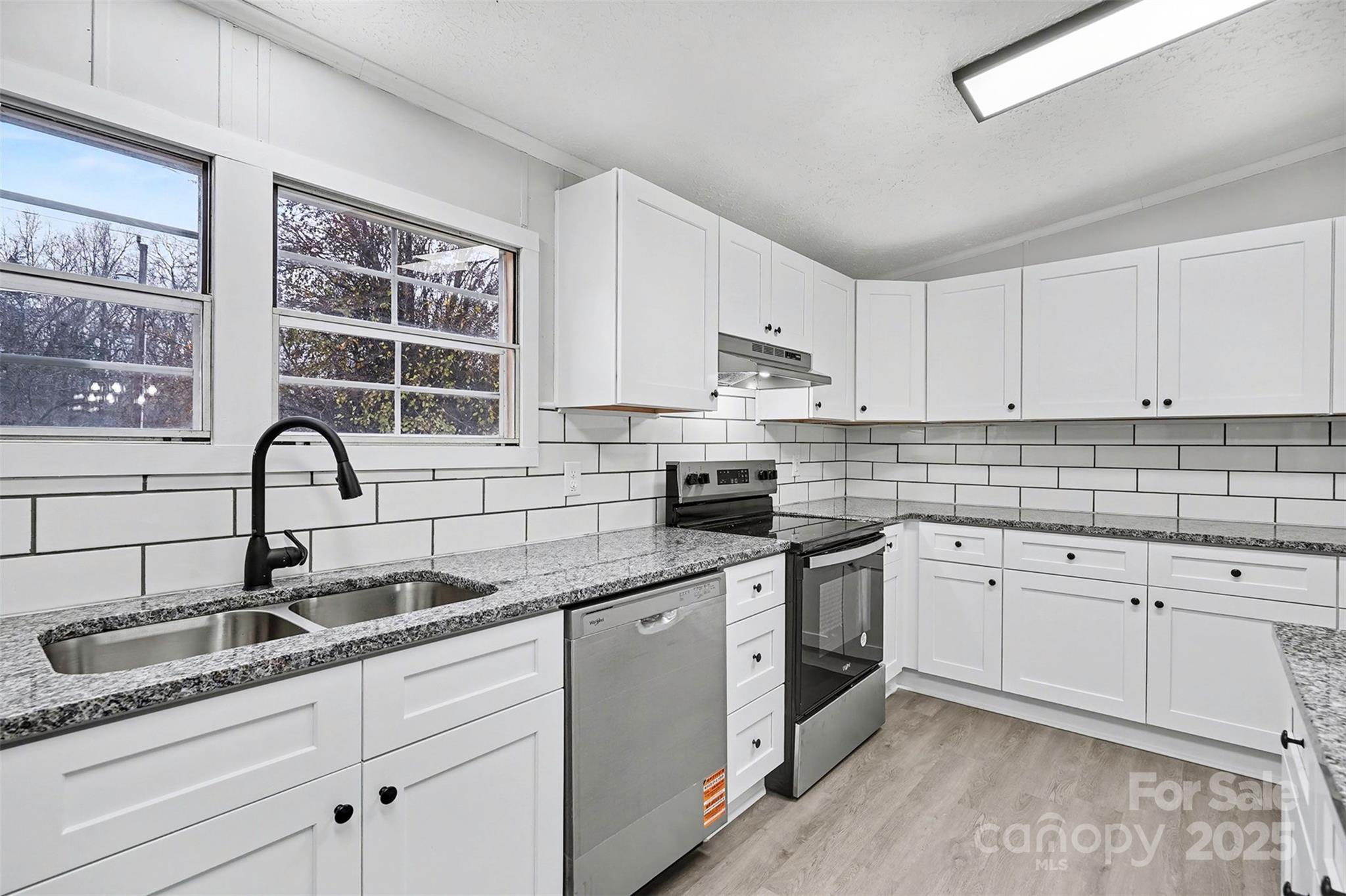 115 Lakeview Lane China Grove, NC 28023 - Photo 12 of 32 a kitchen with granite countertop white cabinets and white appliances