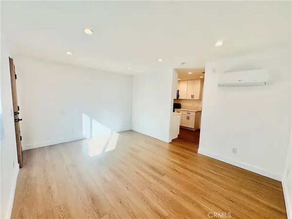an empty room with wooden floor and entrance