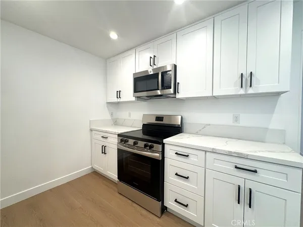 a kitchen with a sink cabinets and wooden floor