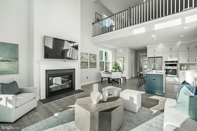 a kitchen with stainless steel appliances a sink a stove a refrigerator and white cabinets with wooden floor