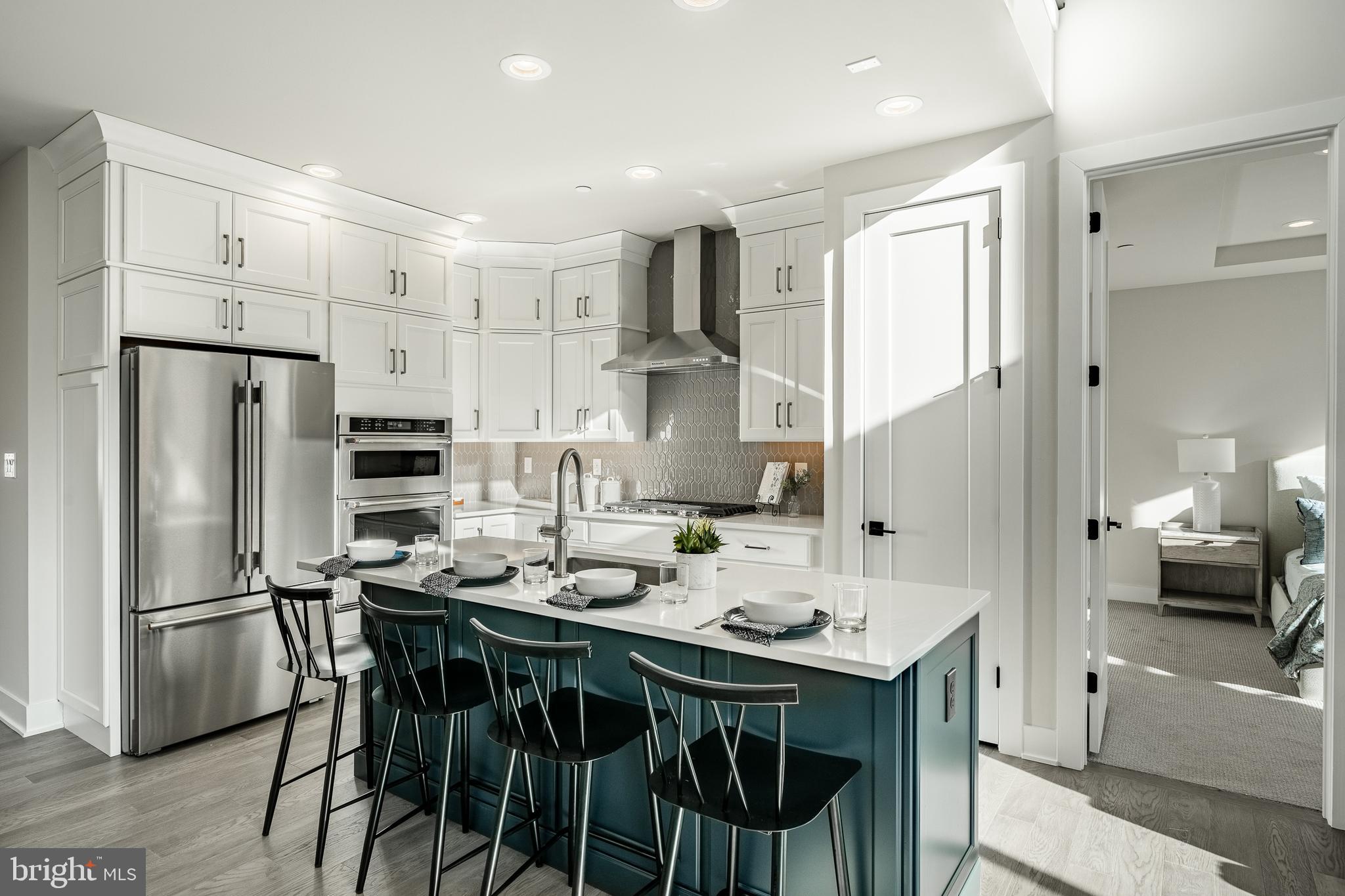 581 Trifecta Road Downingtown, PA 19335 - Photo 15 of 45 a kitchen with stainless steel appliances a sink a stove a refrigerator and white cabinets with wooden floor