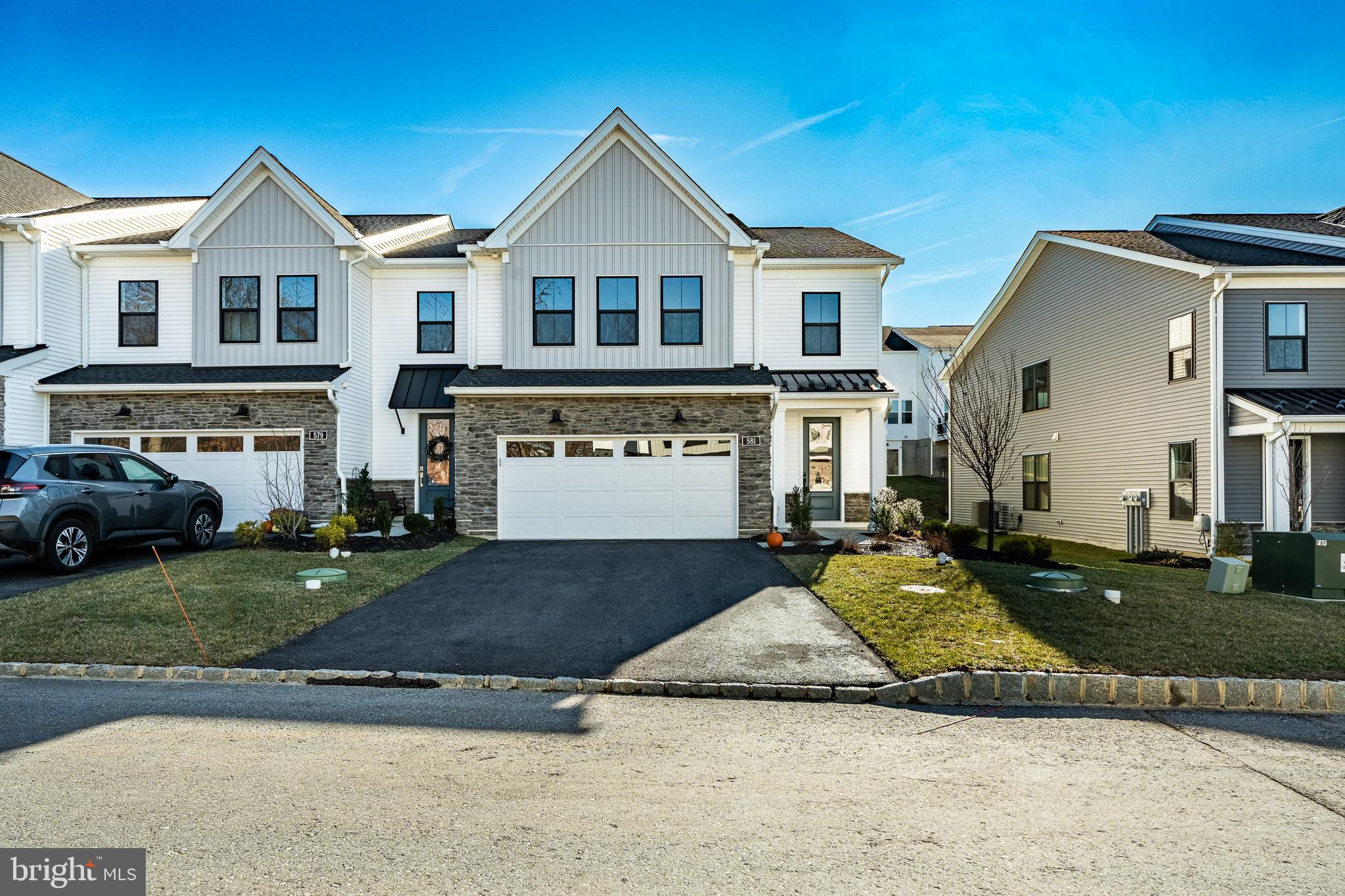 581 Trifecta Road Downingtown, PA 19335 - Photo 2 of 45 a view of a white house with a yard and table and chairs under an umbrella