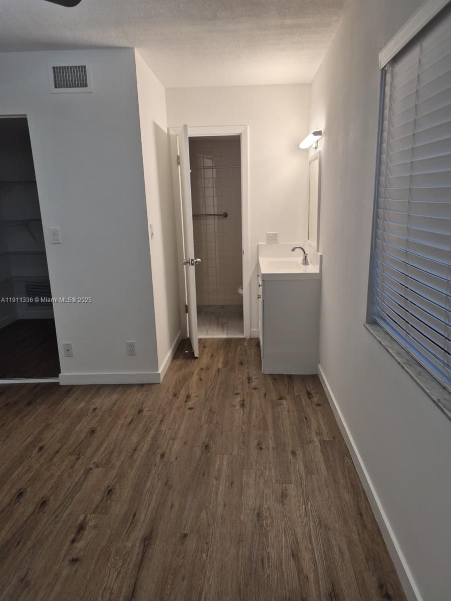 116 Northwest 60th Avenue, Unit 11 Margate, FL 33063 - Photo 11 of 18 wooden floor in an empty room with a window