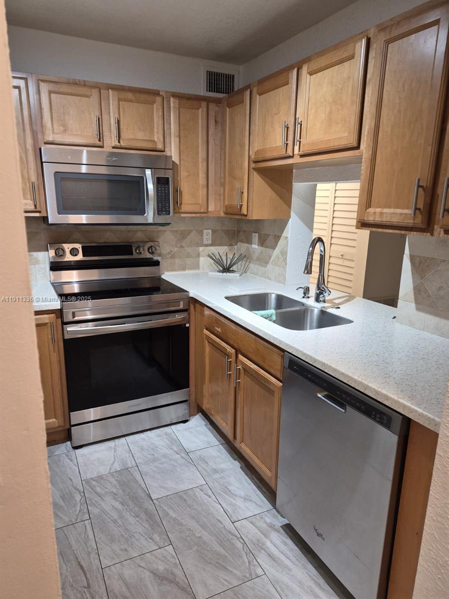 116 Northwest 60th Avenue, Unit 11 Margate, FL 33063 - Photo 4 of 18 a kitchen with a sink stove and microwave