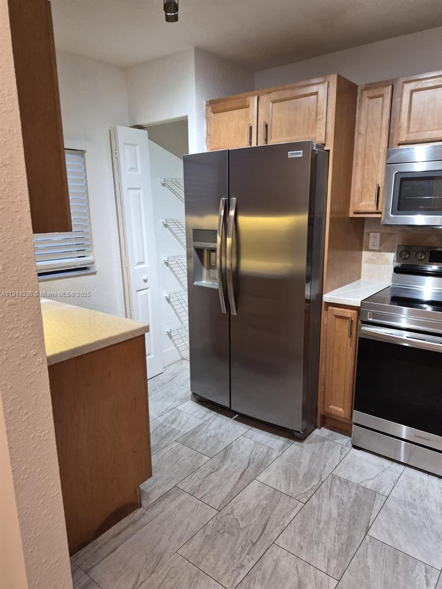 116 Northwest 60th Avenue, Unit 11 Margate, FL 33063 - Photo 5 of 18 a kitchen with stainless steel appliances granite countertop a refrigerator and a stove