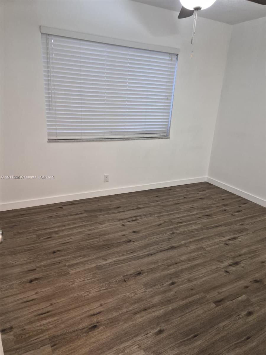 116 Northwest 60th Avenue, Unit 11 Margate, FL 33063 - Photo 6 of 18 an empty room with wooden floor and windows
