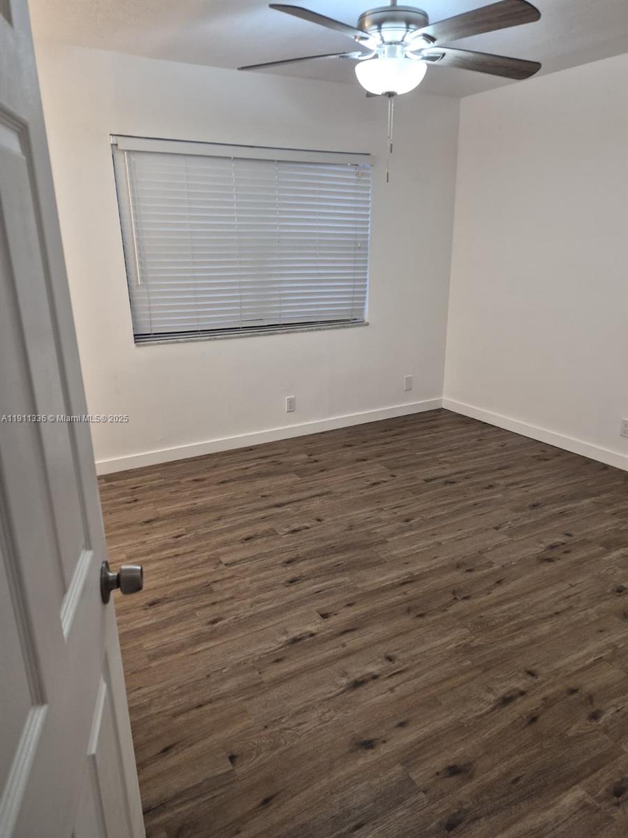 116 Northwest 60th Avenue, Unit 11 Margate, FL 33063 - Photo 7 of 18 a view of an empty room with wooden floor and a window