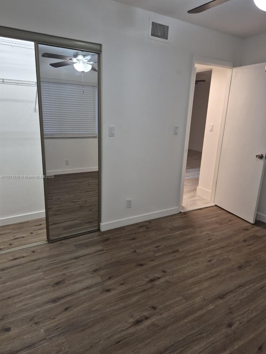 116 Northwest 60th Avenue, Unit 11 Margate, FL 33063 - Photo 9 of 18 a view of an empty room with wooden floor and a window