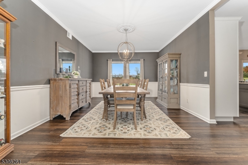 7 Maple Springs Road Pittstown, NJ 08867 - Photo 12 of 41 a dining room with wooden floor a chandelier a wooden table and chairs