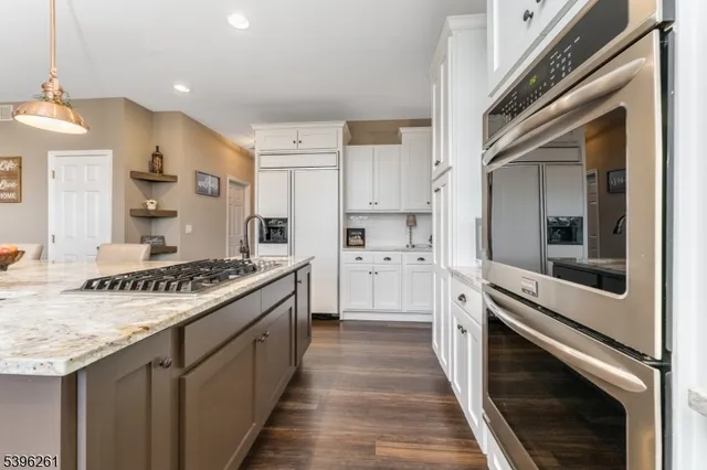 a kitchen with stainless steel appliances granite countertop a sink stove and wooden floor