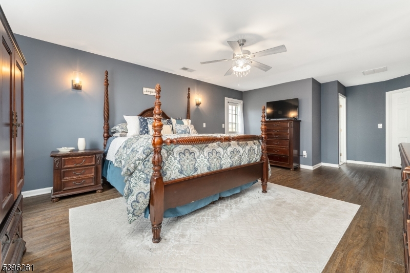 7 Maple Springs Road Pittstown, NJ 08867 - Photo 28 of 41 a bedroom with a bed lamps and a chandelier