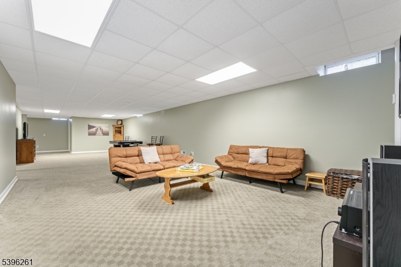 7 Maple Springs Road Pittstown, NJ 08867 - Photo 37 of 41 a living room with furniture a flat screen tv and gym equipment