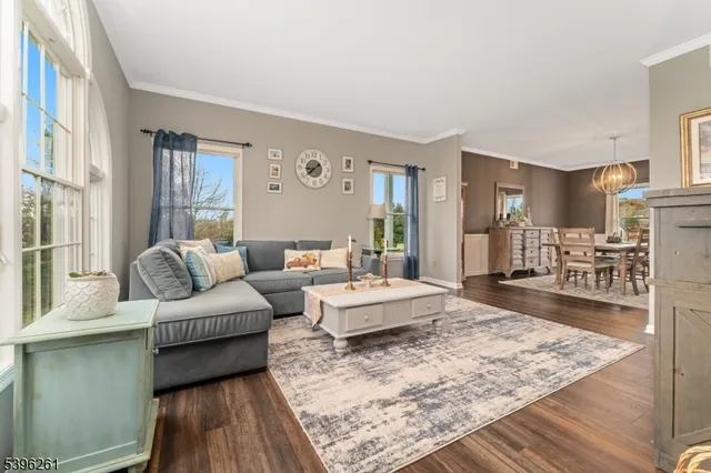 a dining room with wooden floor a chandelier a wooden table and chairs