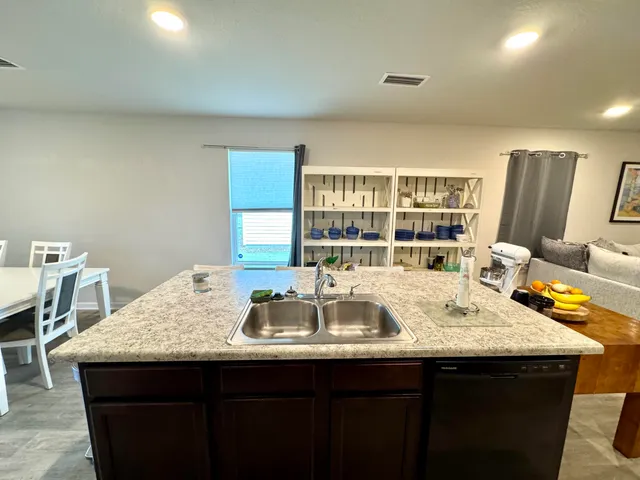 a kitchen with granite countertop a sink and a wooden floor