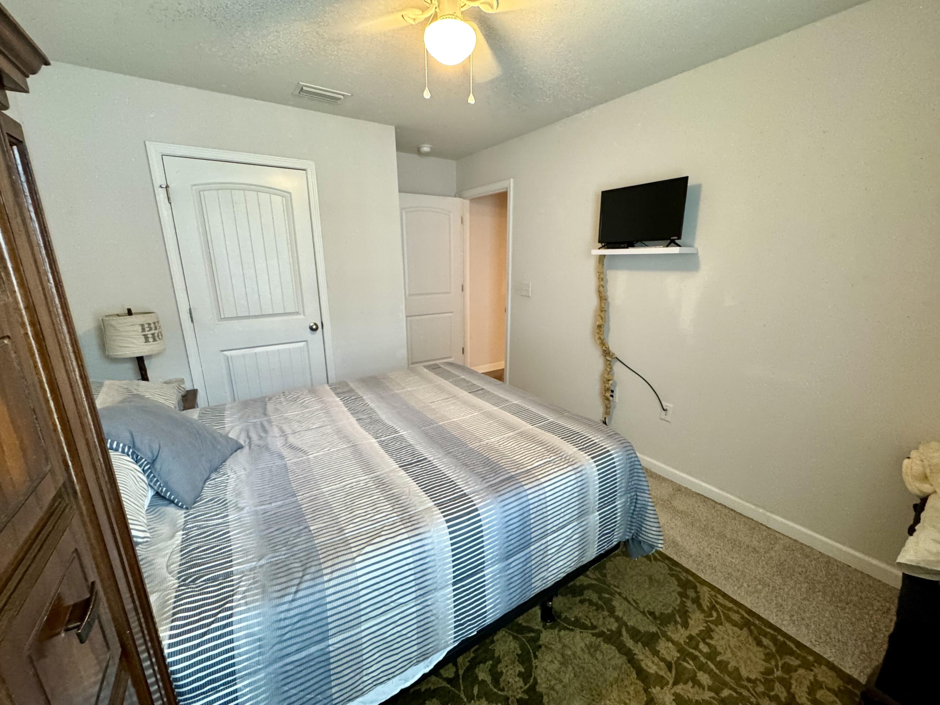629 Earl Godwin Road Freeport, FL 32439 - Photo 17 of 36 a bedroom with a bed and a flat tv screen on dresser