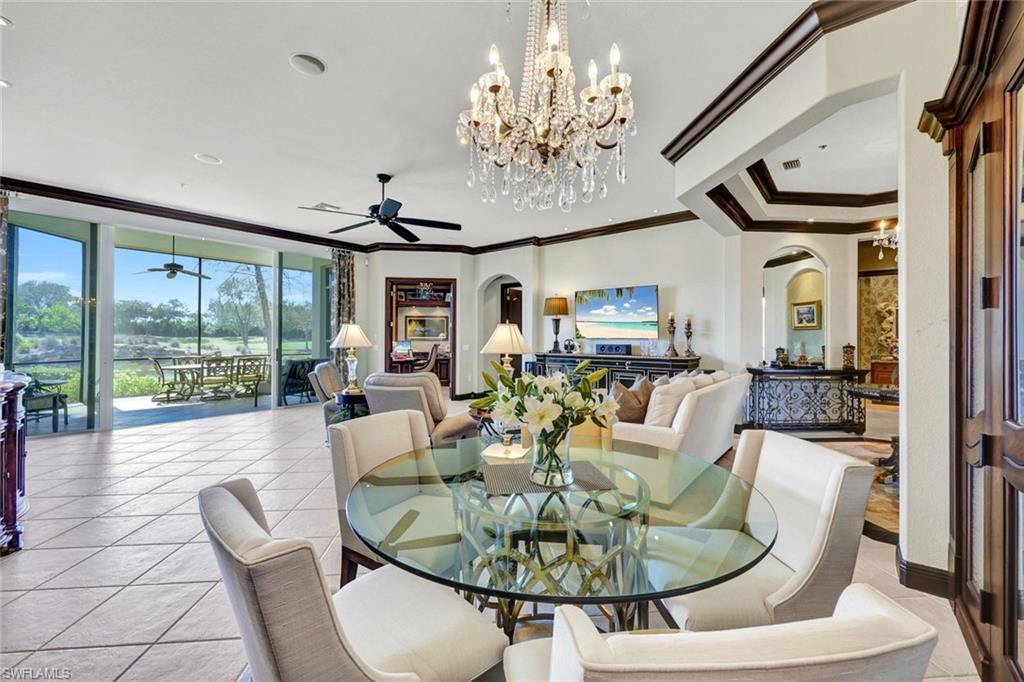15516 Monterosso Lane, Unit 101 Naples, FL 34110 - Photo 11 of 31 Dining room featuring arched walkways, hanging lights, expansive windows, light tile patterned flooring, and a ceiling fan