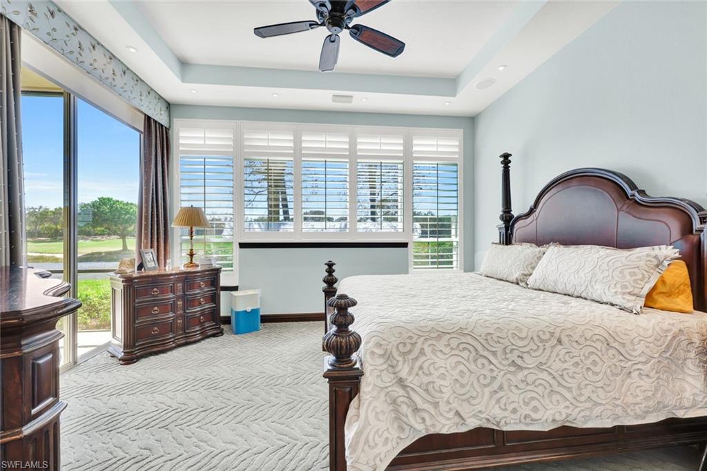 15516 Monterosso Lane, Unit 101 Naples, FL 34110 - Photo 15 of 31 Bedroom featuring light carpet, access to exterior, a ceiling fan, and a raised ceiling