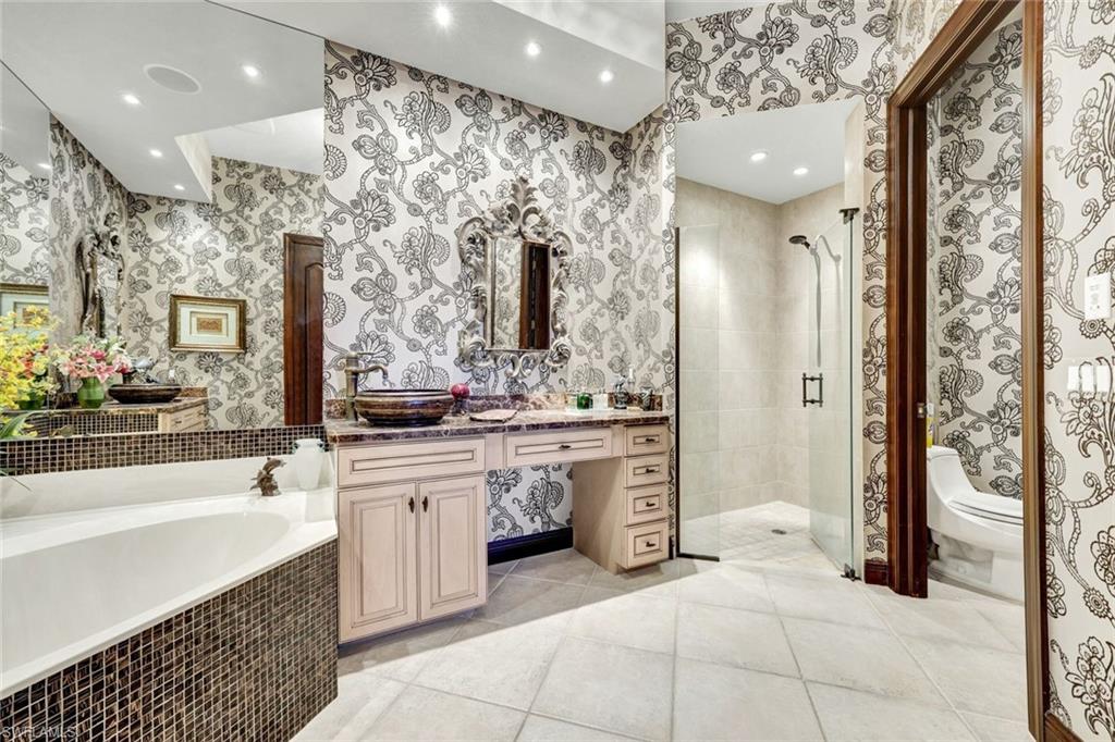 15516 Monterosso Lane, Unit 101 Naples, FL 34110 - Photo 18 of 31 Bathroom with vanity, a shower stall, light tile patterned floors, a garden tub, and recessed lighting
