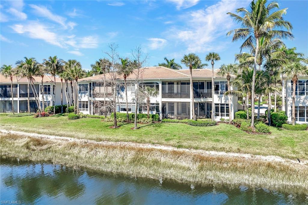 15516 Monterosso Lane, Unit 101 Naples, FL 34110 - Photo 26 of 31 Back of property featuring a water view and a lawn