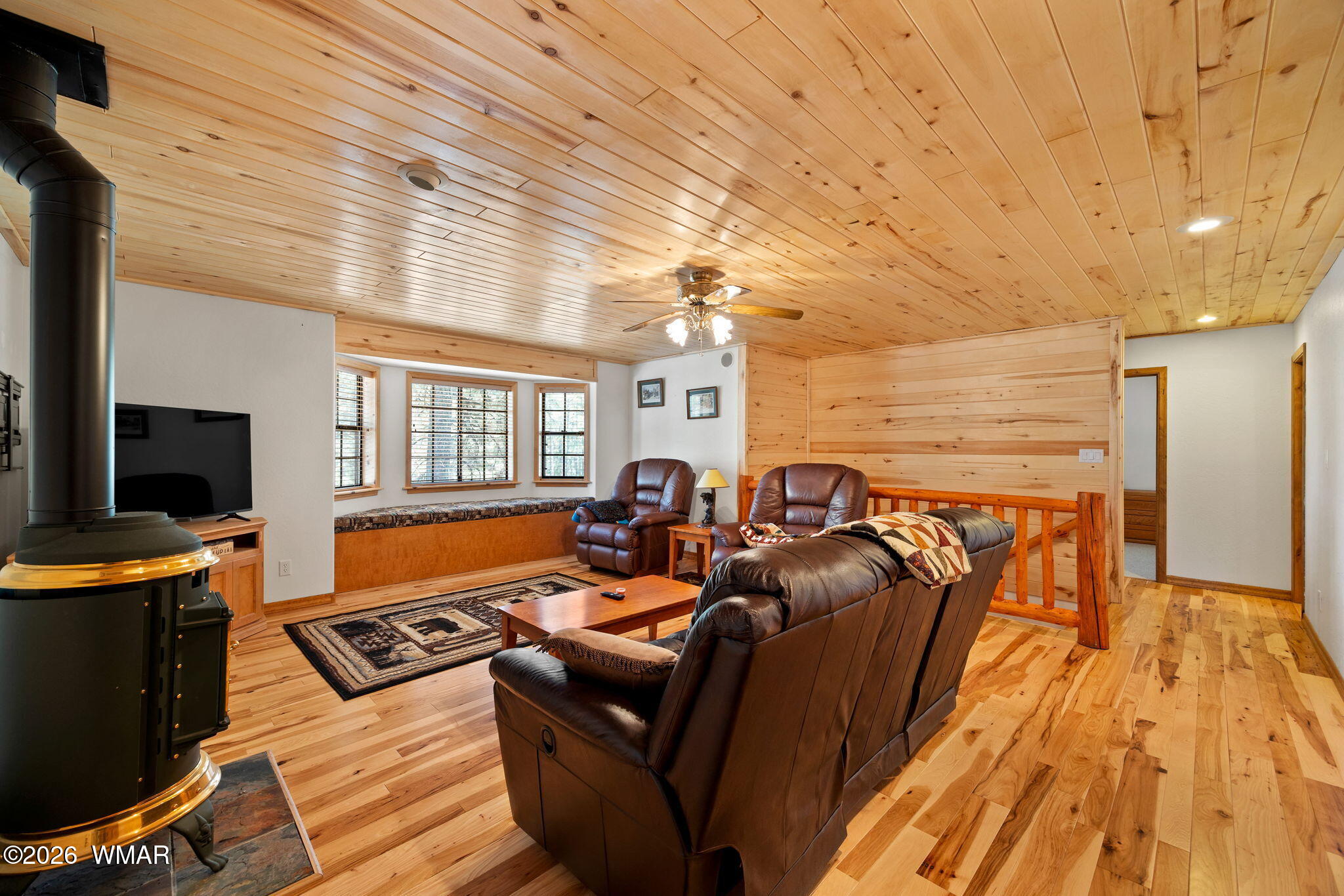 48 North 1068th Street Greer, AZ 85927 - Photo 16 of 37 a living room with furniture a flat screen tv and a floor to ceiling window