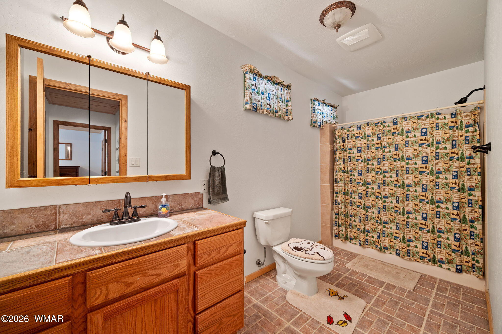 48 North 1068th Street Greer, AZ 85927 - Photo 22 of 37 a bathroom with a granite countertop toilet a sink a mirror a shower and a window